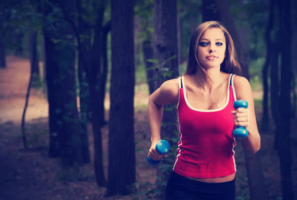 woman running with dumbbells