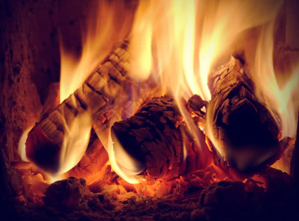 crest of flame on burning wood in fireplace