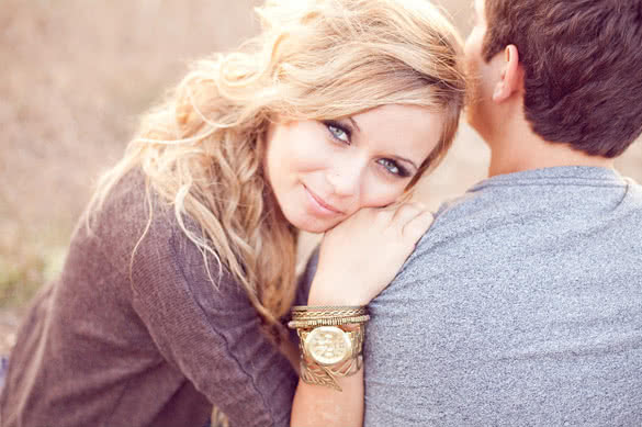 Beautiful blonde girl touching shoulder of her man