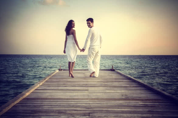 happy loving couple in white clothes posing on a pier