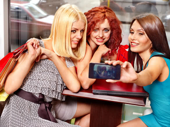 gossip women with laptop in a cafe