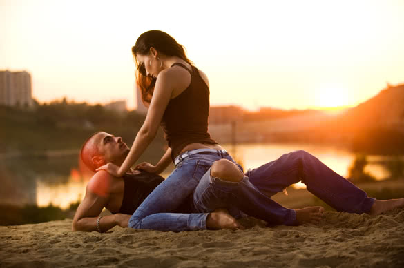 beautiful young couple lying on the sand