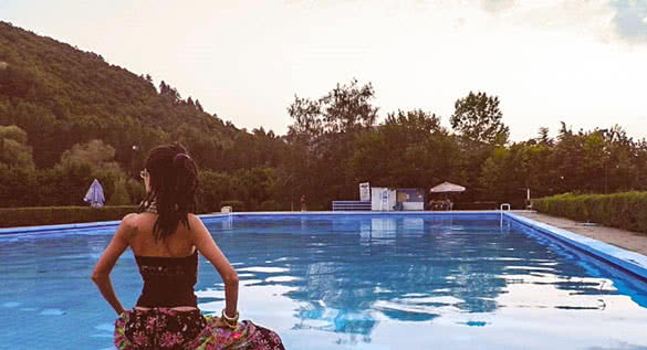 woman sitting by the swimming pool