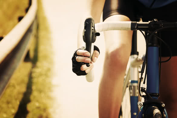 Cropped view of female cyclist with hands on brakes
