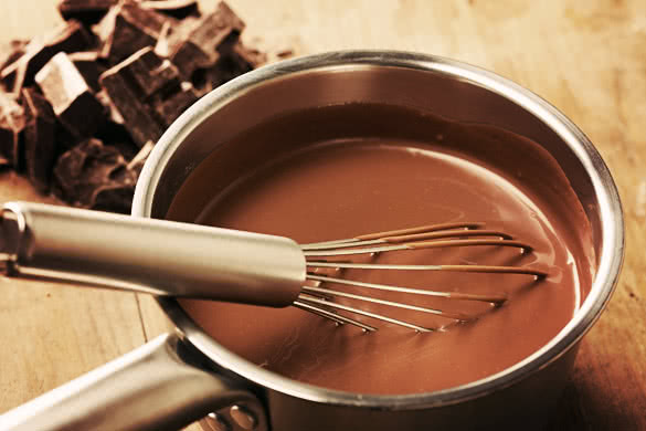 Preparing hot chocolate in a pot on wooden table