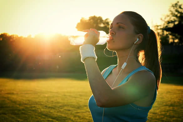 Young woman drinking water after run