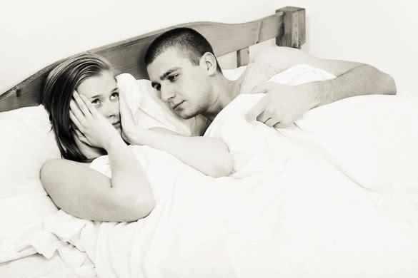 Young couple lying in bed having sexual disfunction