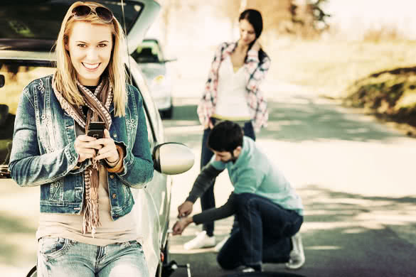 Puncture wheel man changing tire help two female friends