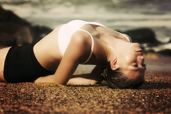 young woman doing yoga pose on the beach