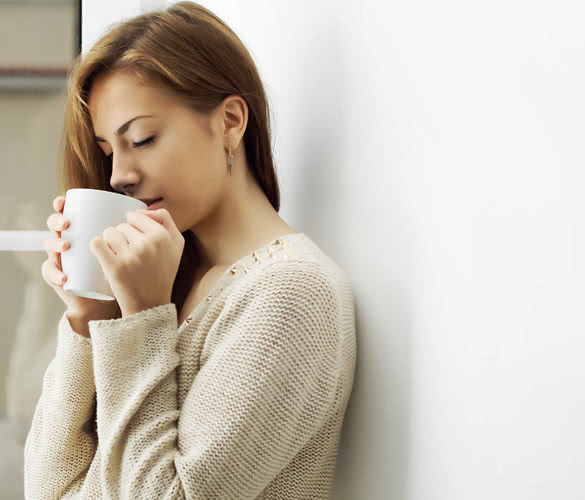 Girl with a cup in profile at the window