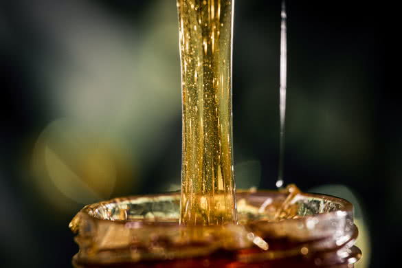 Honey dripping from a wooden honey dipper