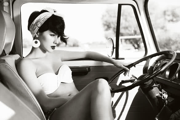 Sensual young woman relaxing in car near the beach