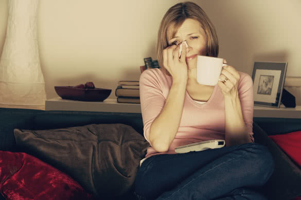 Woman Relaxing With Cup Of Coffee Watching Television