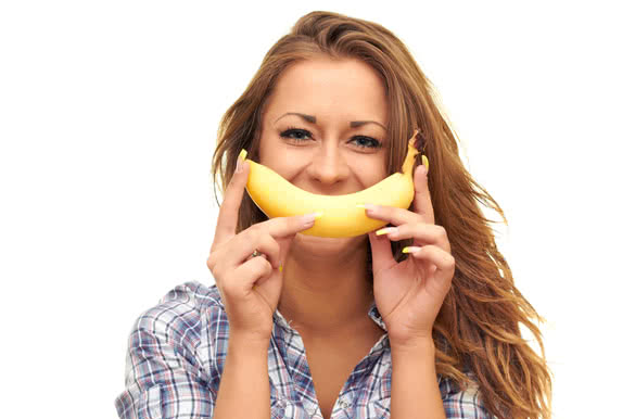 girl isolated on white background holding a banana near the mouth