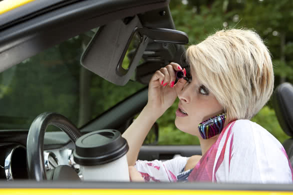 Beautiful young woman distracted while driving