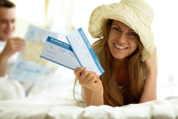 Elegant woman in hat holding flight tickets