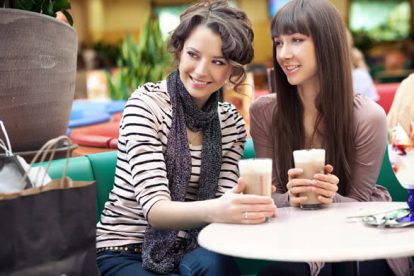 Friends having lunch at a cafe laughing and smiling