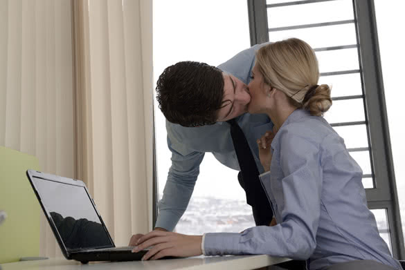 two young bussines people kissing in office
