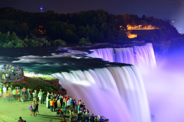 Niagara Falls lit at night by colorful lights