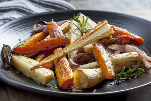 Roasted root vegetables on a black serving platter