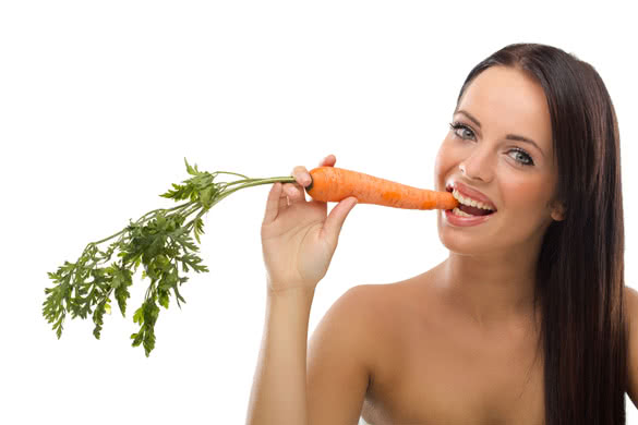 beautiful funny woman biting raw carrot