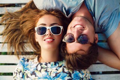 happy smiling couple in love laying in wood white floor