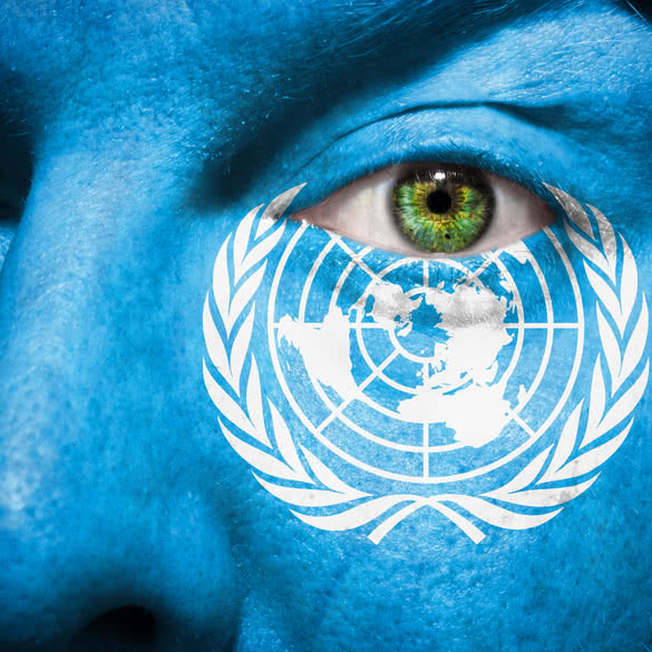 Flag painted on face with green eye to show United Nations support