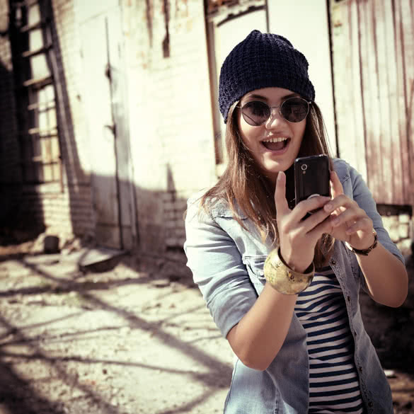 Pretty young woman using mobile phone and getting photos