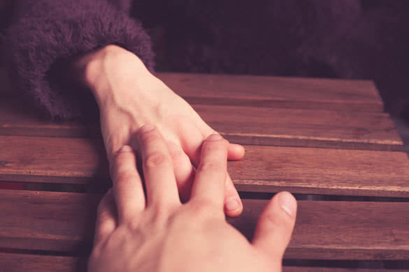A young couple touching hands at a table