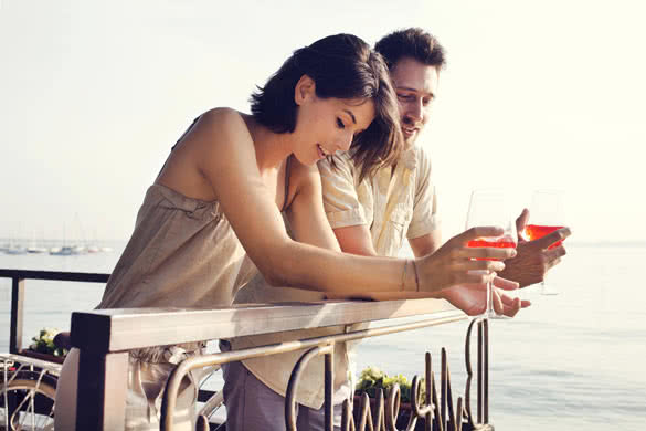 Couple talking while having spritz in a lake view terrace