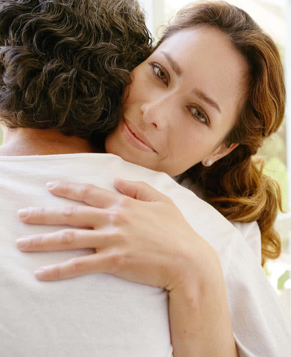 Mature couple hugging in a garden corridor at home