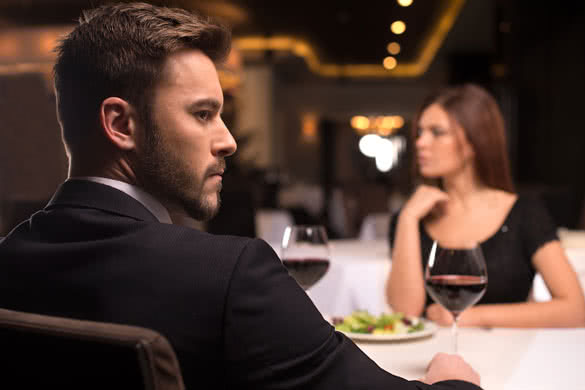 Thoughtful young couple sitting at the restaurant and looking away