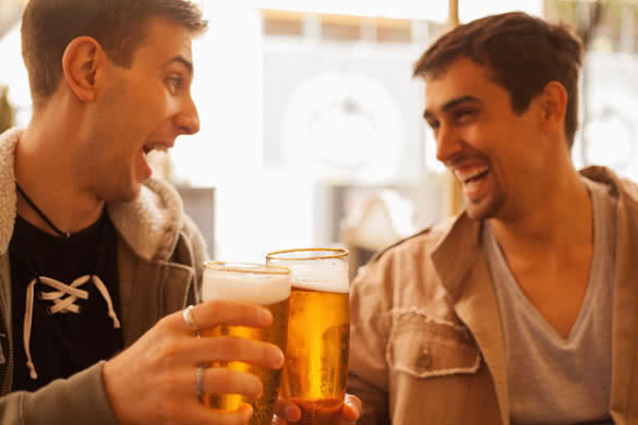 Young cheerful men having fun drinking beer outdoors