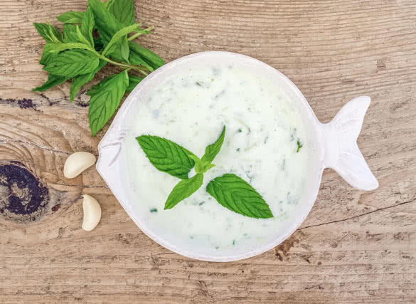 A bowl of cold yogurt and cucumber soup with garlic and fresh mint