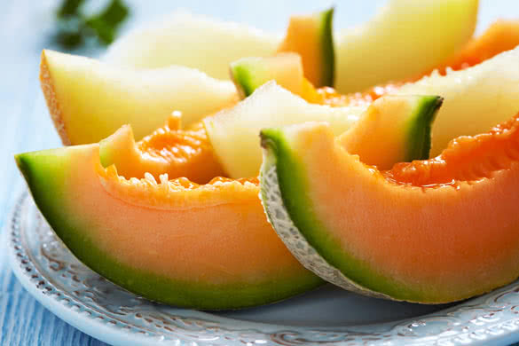 Cantaloupe melon slices on blue wooden table