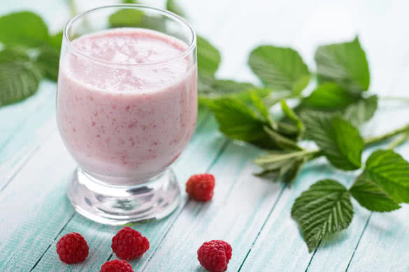 Smoothie drink with raspberry on aqua background
