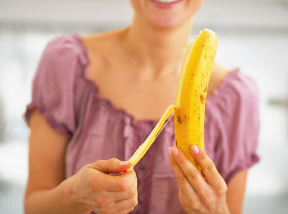 young woman peeling banana