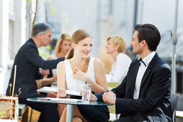 Business man and woman flirting outdoors in a coffee shop