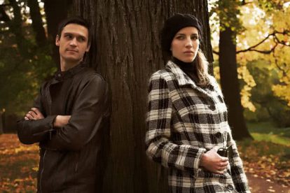 The young couple which has quarrelled during their walk in a park