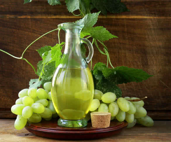 jugful with grape seed oil on a wooden table