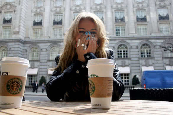 woman laughing and drinking sturbucks coffee