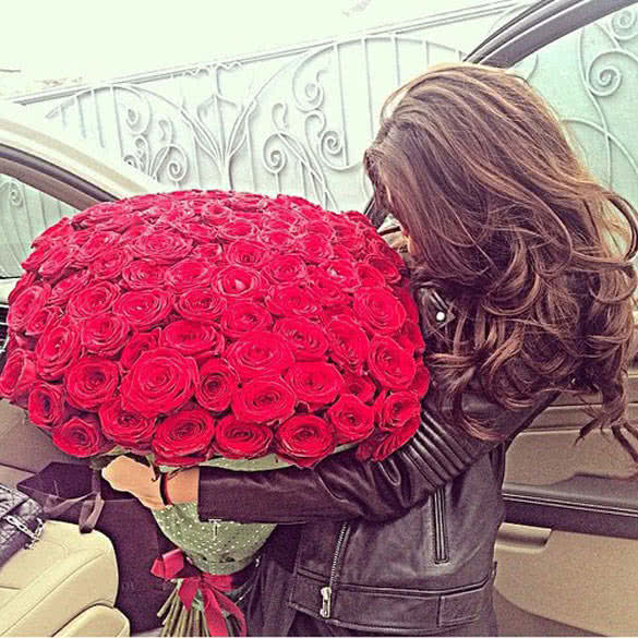 young woman holding beautiful red flowers