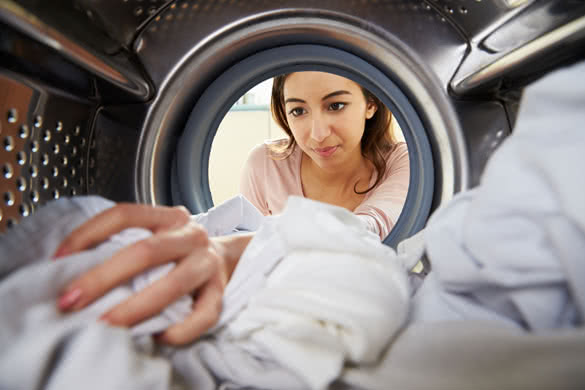 Woman-Doing-Laundry-Reaching-Inside-Washing-Machine