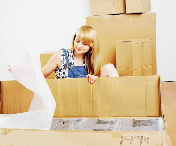 Young-blond-woman-unpacking-box-of-new-furniture