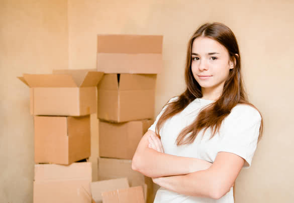 girl-standing-on-a-background-of-cardboard-boxes