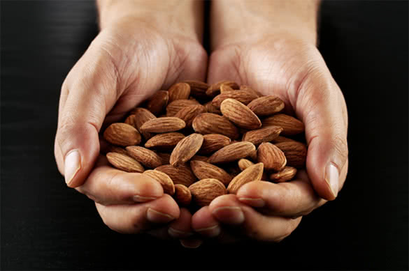 man-hands-holding-lot-of-almonds