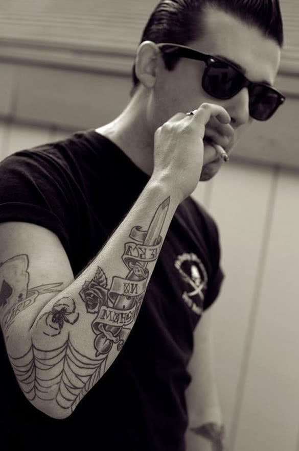 man-with-tattooed-arm-and-sunglasses-smoking