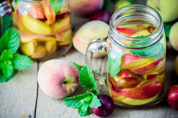 Jar delicious refreshing drink of peach fruits and plum with mint