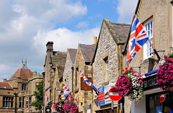 Row of British flags on shop walls in the town centre Bakewell