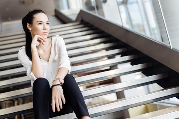 Businesswoman sitting on stairs and thinking